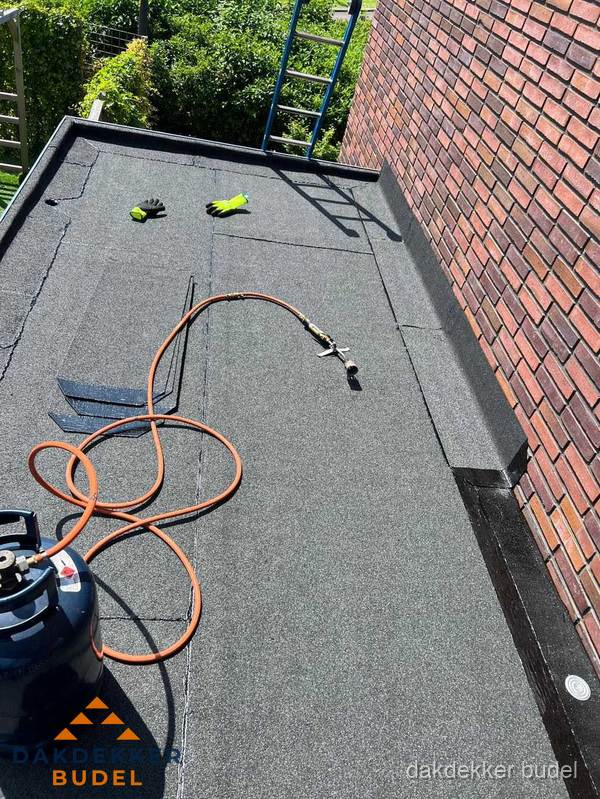 Plat dak met bitumen en brandgereedschap van dakdekkersbedrijf in Budel Plat dak met bitumen en brandgereedschap van dakdekkersbedrijf in Budel